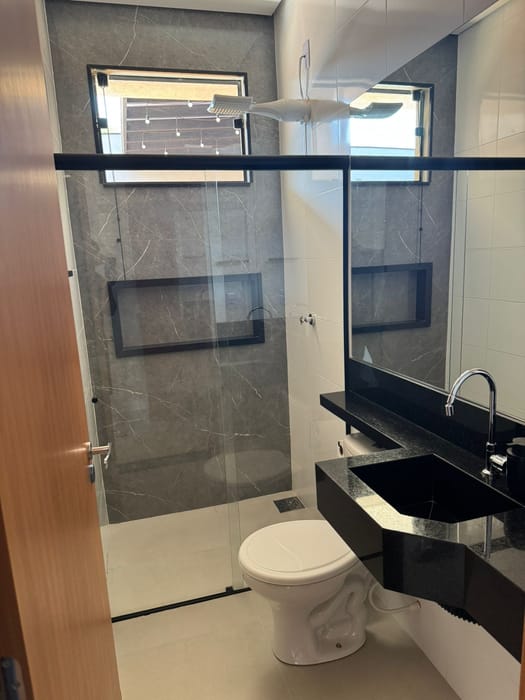Banheiro da suíte, com box e bancada em granito